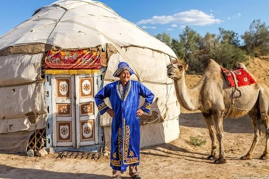 Campamento tradicional de yurtas bajo el cielo nocturno del desierto en Uzbekistán