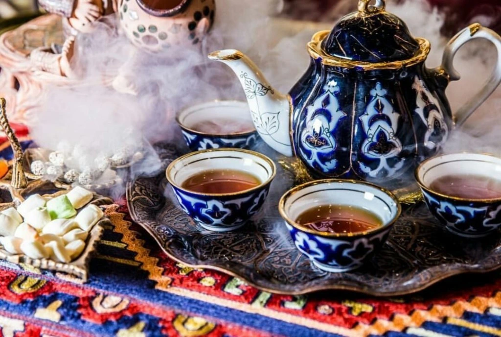 Traditional Uzbek ceramic teapot and tea bowls served in Silk Road style